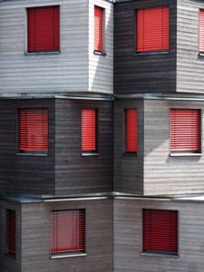 Light and dark exterior siding with red shutters