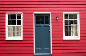 Red siding with blue door and two windows