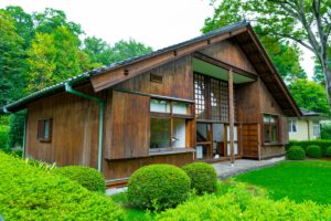 Brown wood cabin in lush green area